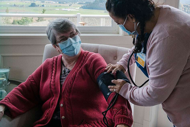 nurse taking blood pressure of patient