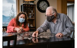 hospice volunteers, hospice volunteer works on a jigsaw puzzle with a patient
