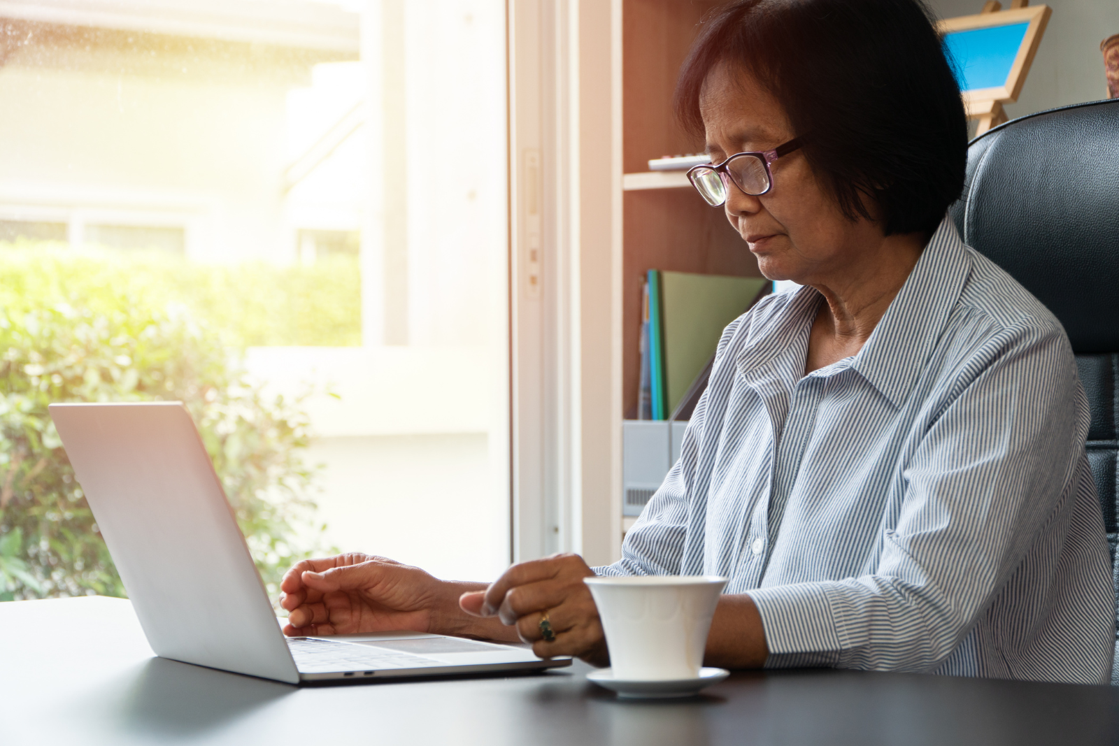 Woman on laptop, attending an online support group.